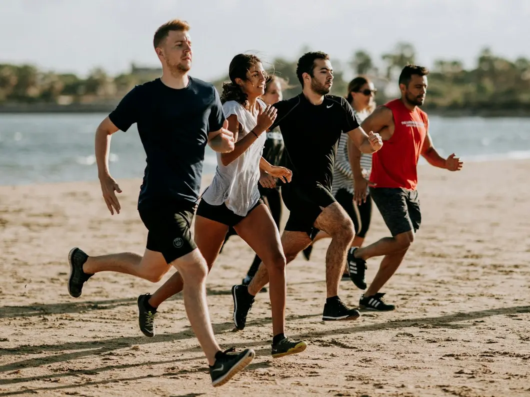 men and women running on sea shore